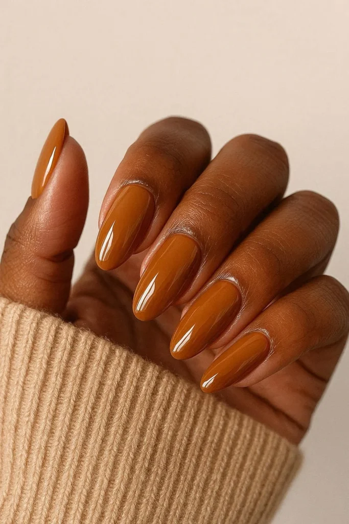 Warm caramel glossy almond nails on deep brown skin