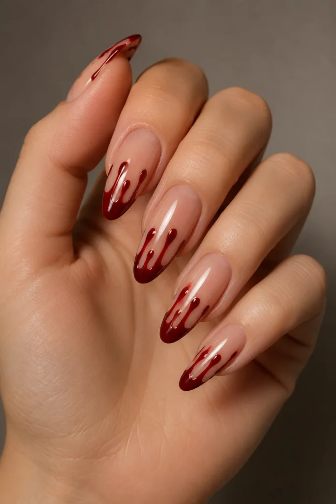 Glossy nude nails with bold red blood drip contrast 