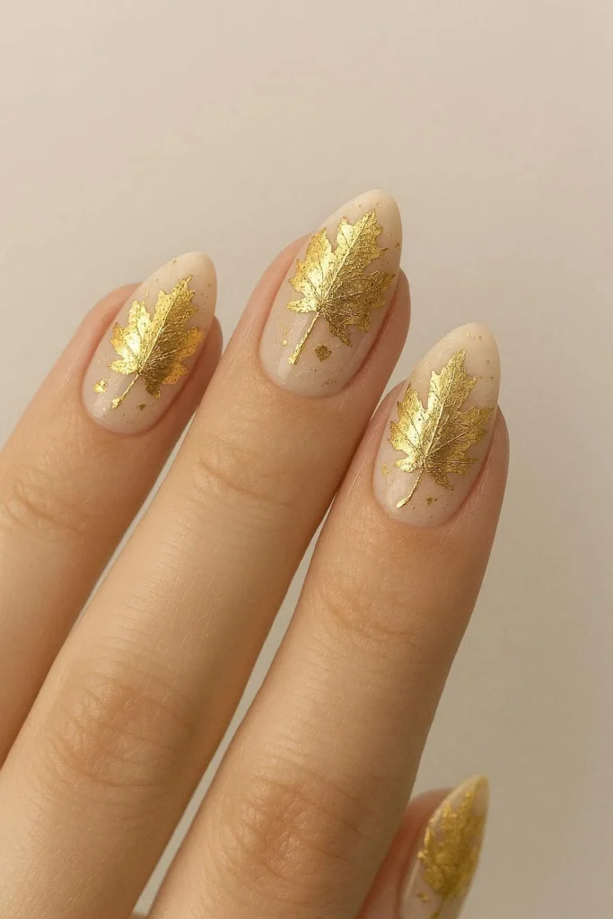 Gold foil maple leaf nails on champagne base