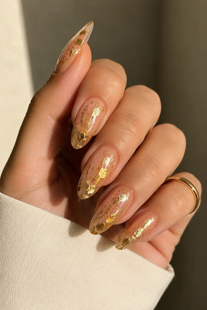 Elegant gold leaf nail art applied over a nude base
