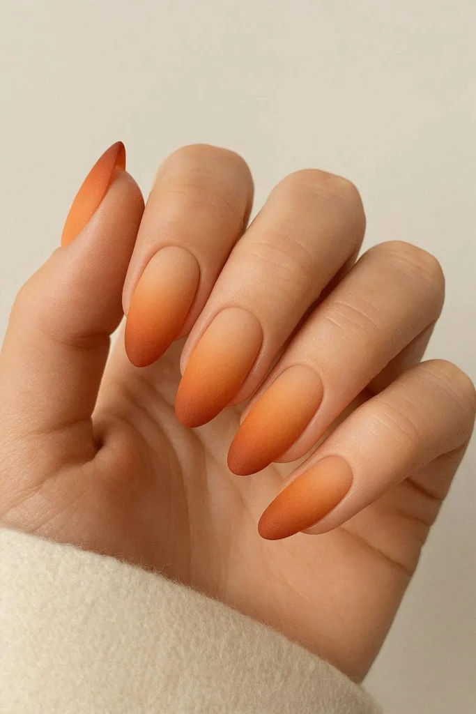 Matte ombre orange nails blending peach to deep autumn orange gradient 