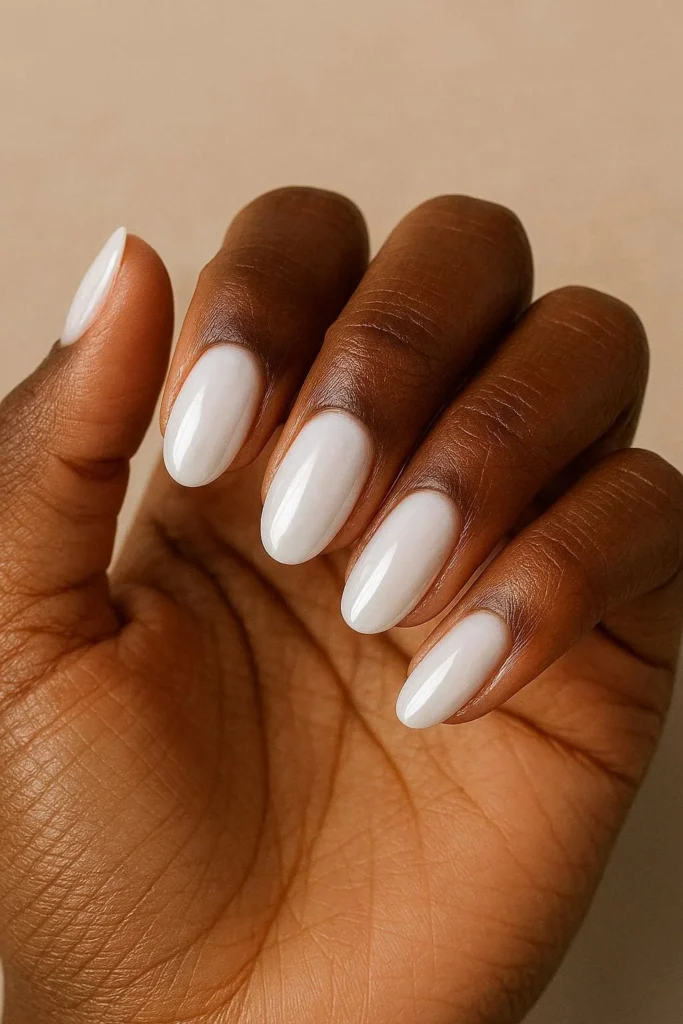 Milky white high-gloss oval nails on deep brown skin
