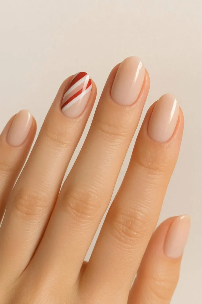 Neutral nails with a single candy cane striped accent nail