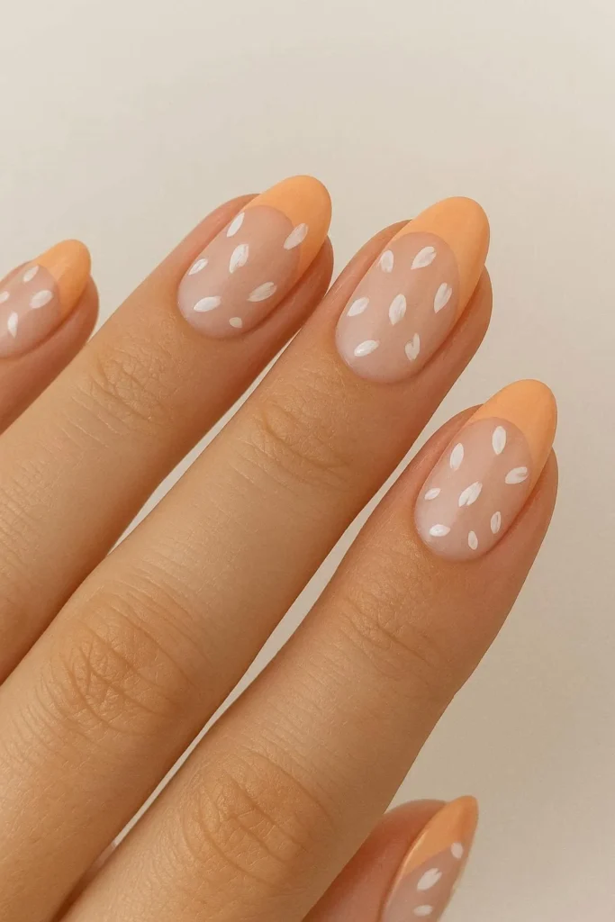 Peach French nails with tiny scattered petal nail art
