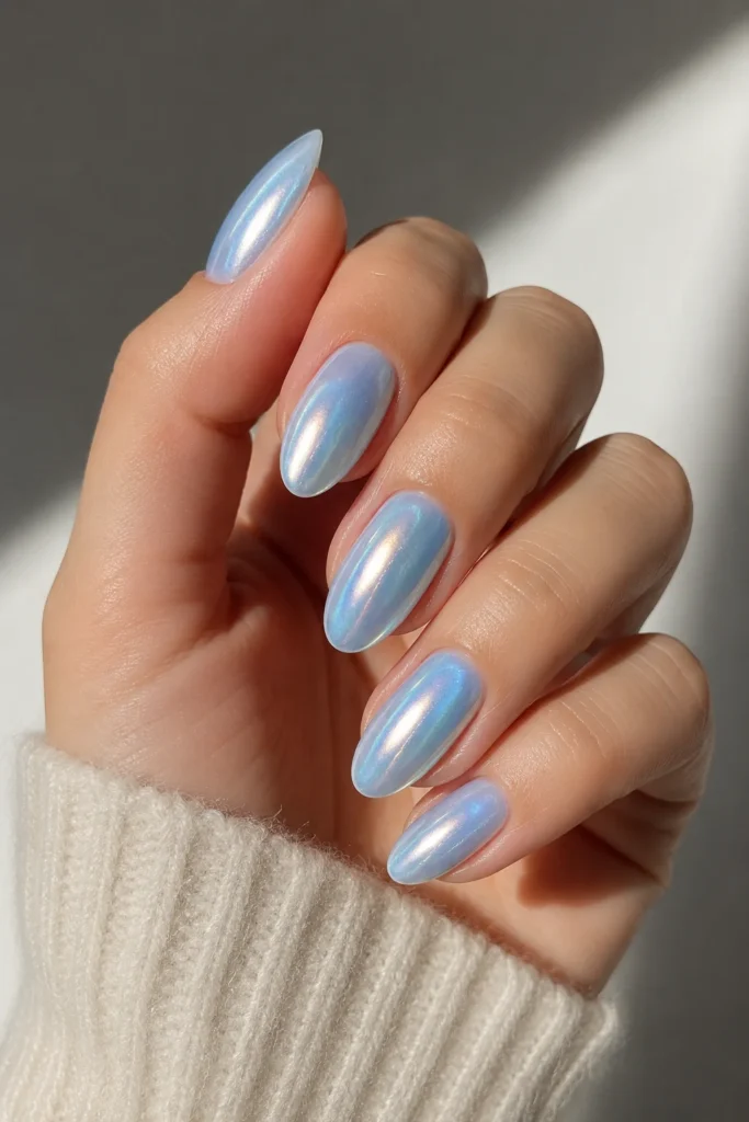 Pearlescent shimmer chrome nails layered over icy blue polish