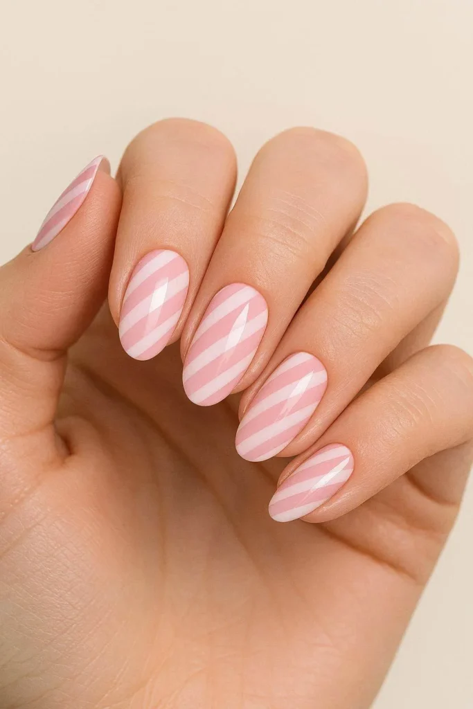 Soft pink and white candy cane stripe nail design