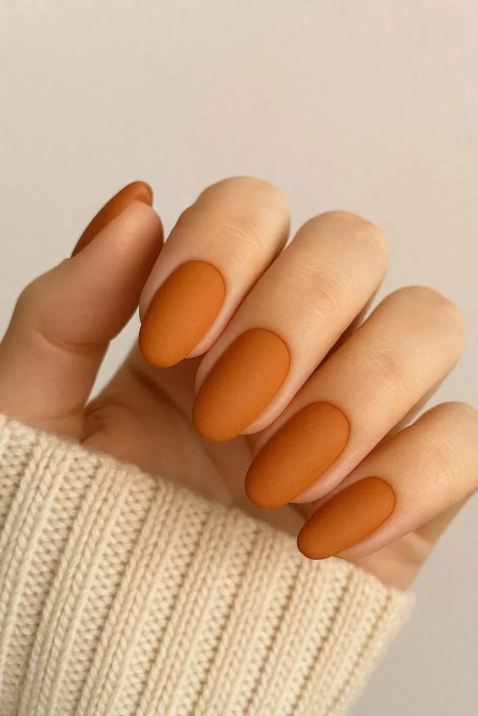 Pumpkin spice matte nails in warm orange tones for sweater weather 