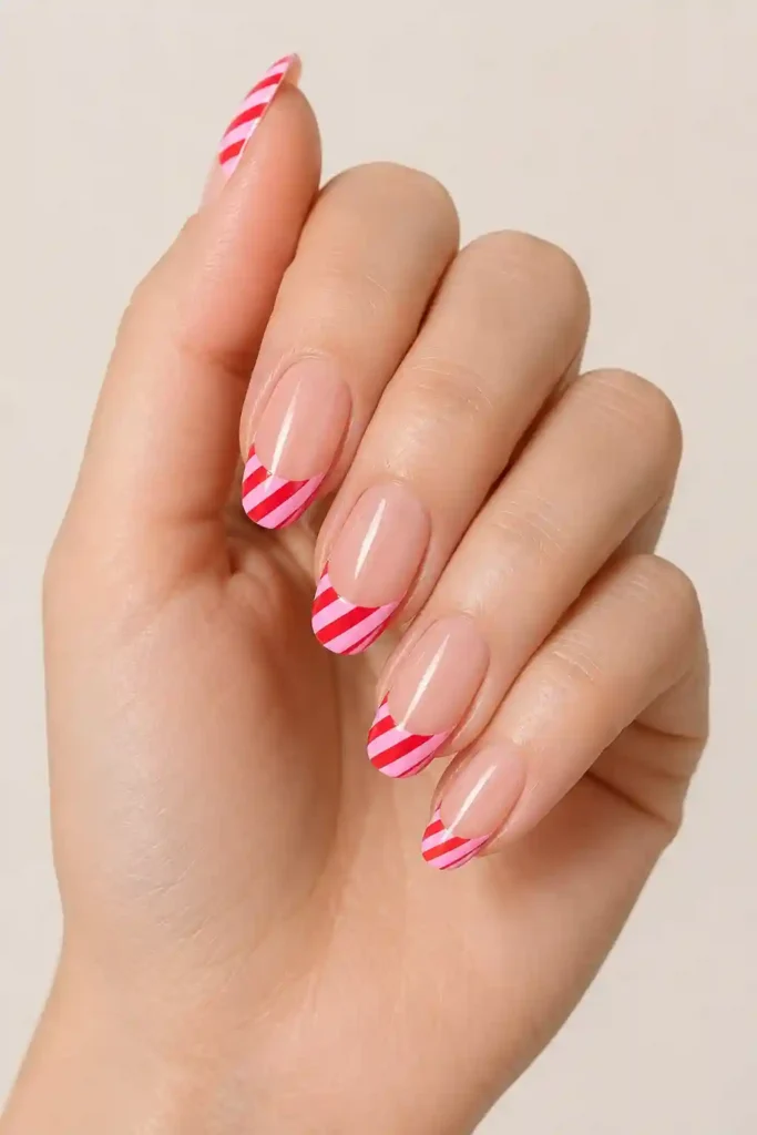 Red and pink candy cane French tip nails modern romantic holiday