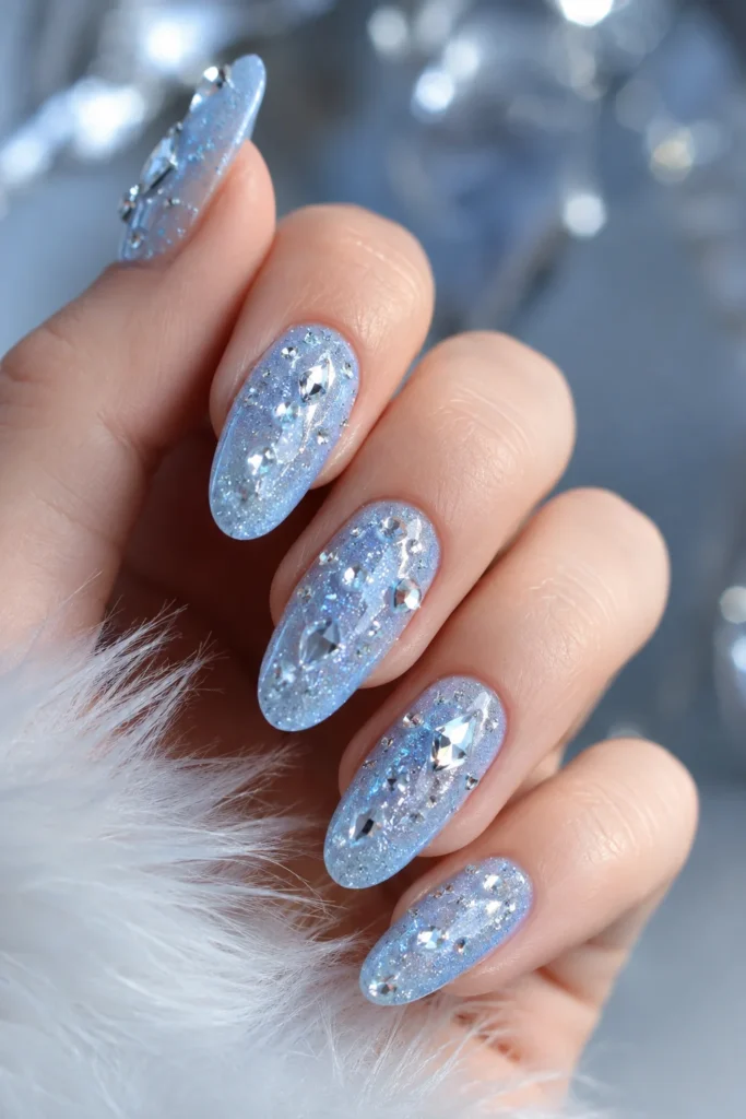 Crystal rhinestone embellishments on a frosted icy blue nail base