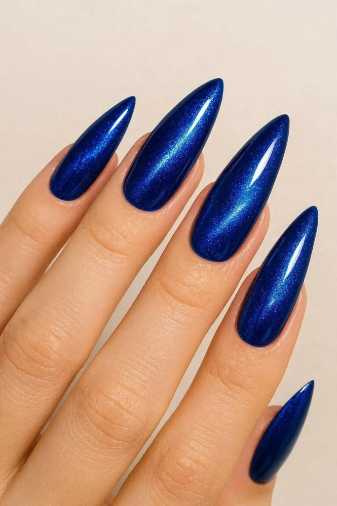 Sapphire blue cat eye nails with electric shimmer on stiletto shape