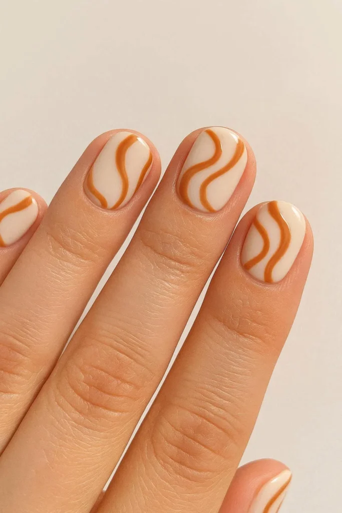 Short caramel swirl nails with autumn-inspired design
