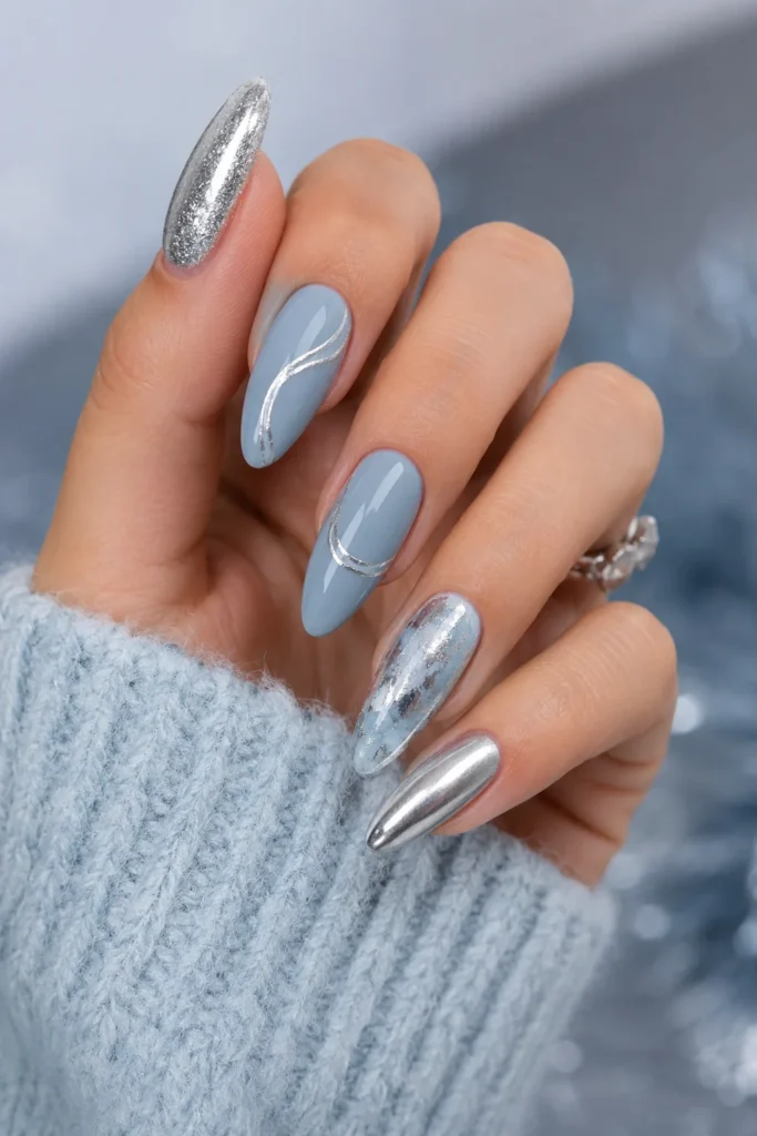 Metallic silver and icy blue nail design with winter accents