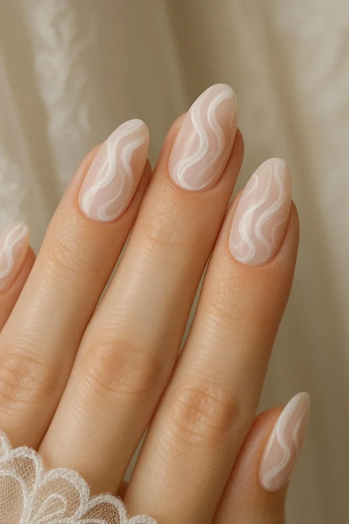 White swirl design over blush pink bridal nails