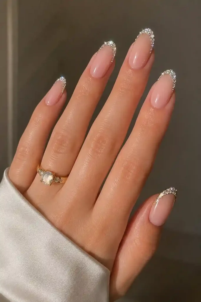 Classic French tip nails elevated with shimmering rhinestone diamonds