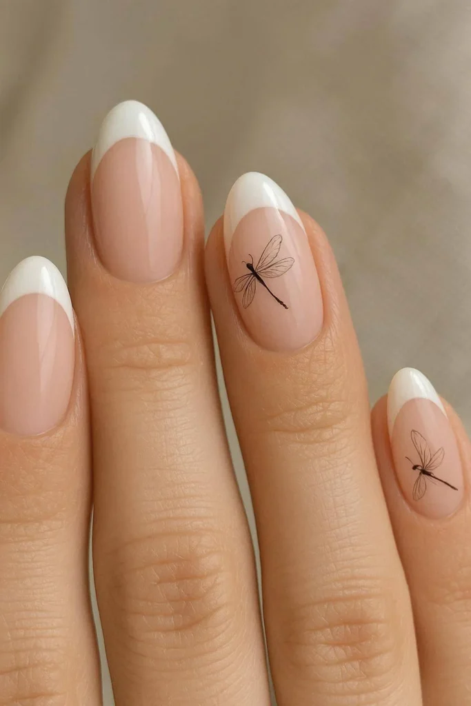 French tip nails with subtle dragonfly artwork