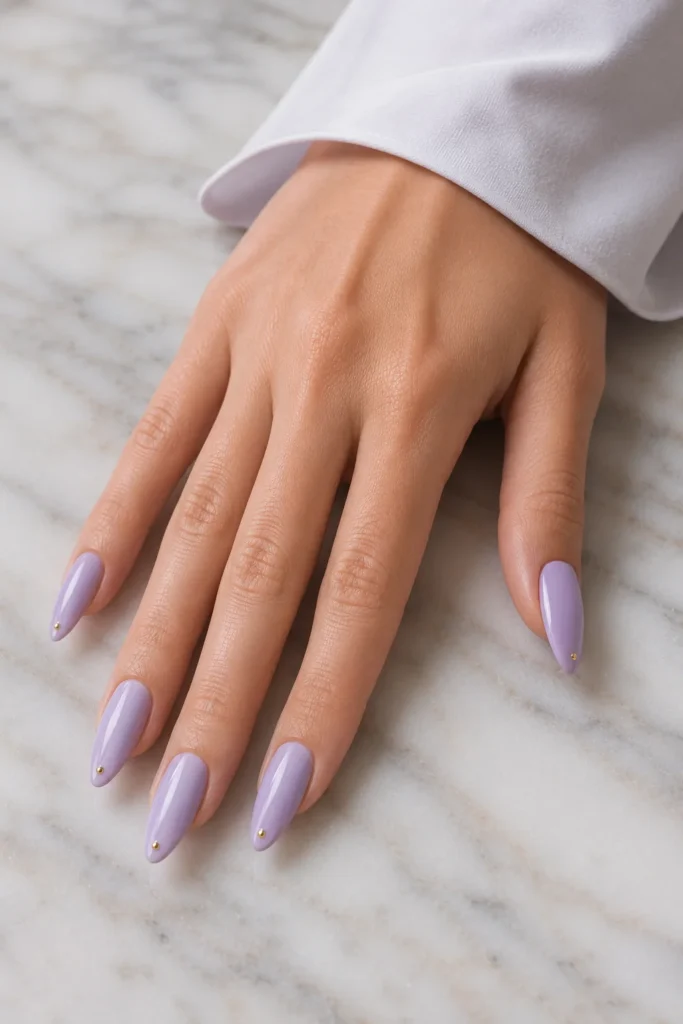 Pastel pointy nails with a single tiny gold dot near the tip