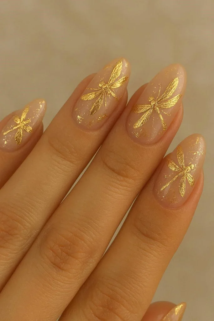 Gold foil accents highlighting graceful dragonfly nail art