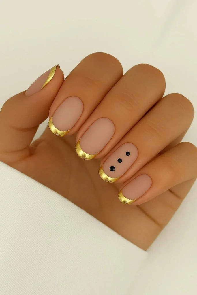 Gold French tip nails with black polka dots