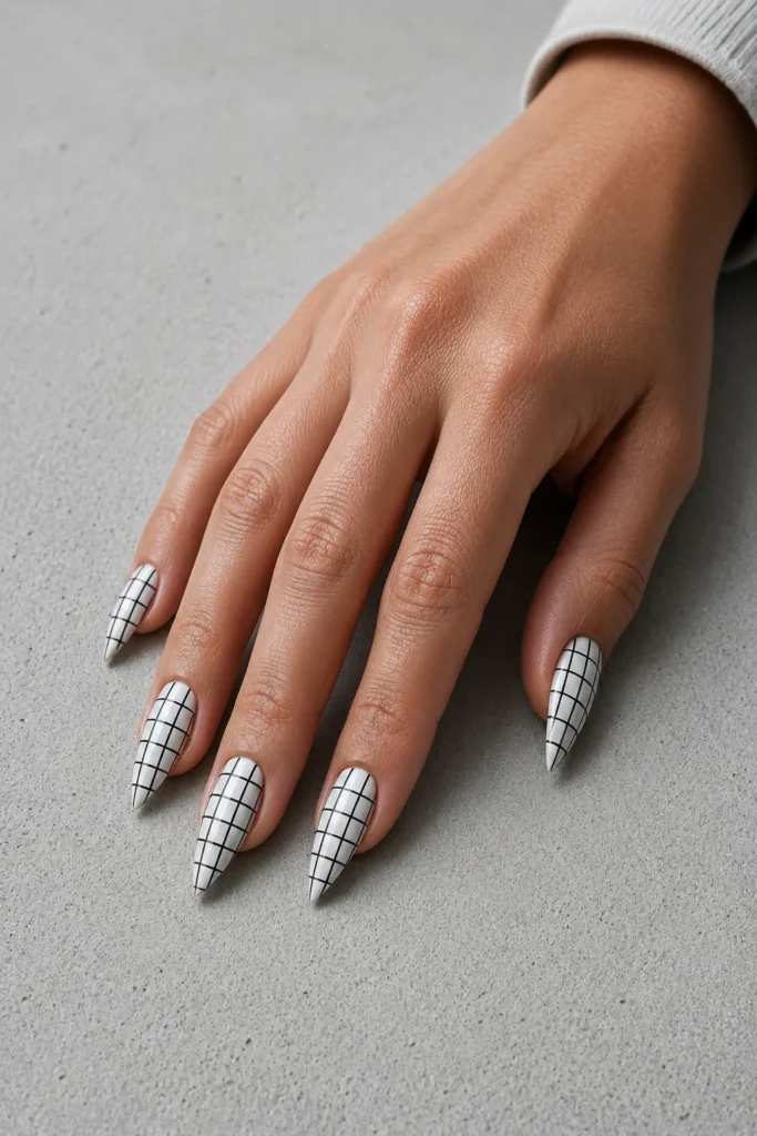 White pointy nails featuring thin black grid line nail art