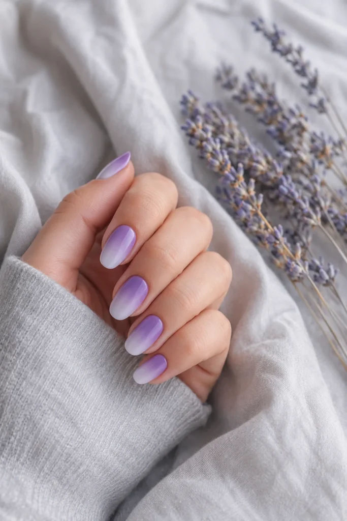 Lavender ombre nails fading from deep purple to white