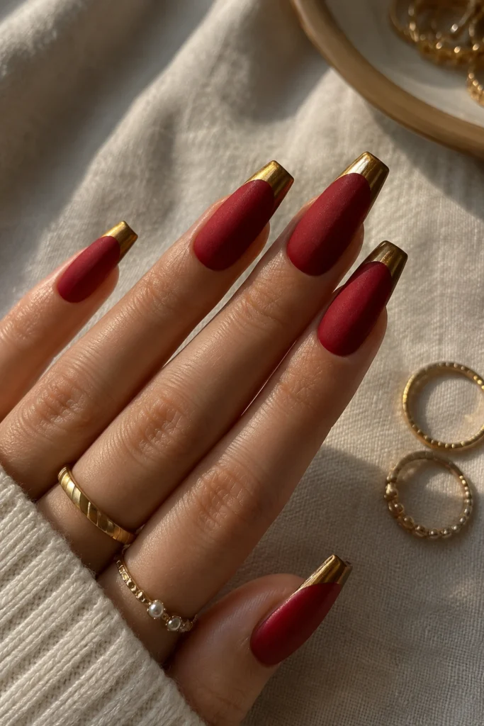 Matte red nails with glossy metallic gold tips