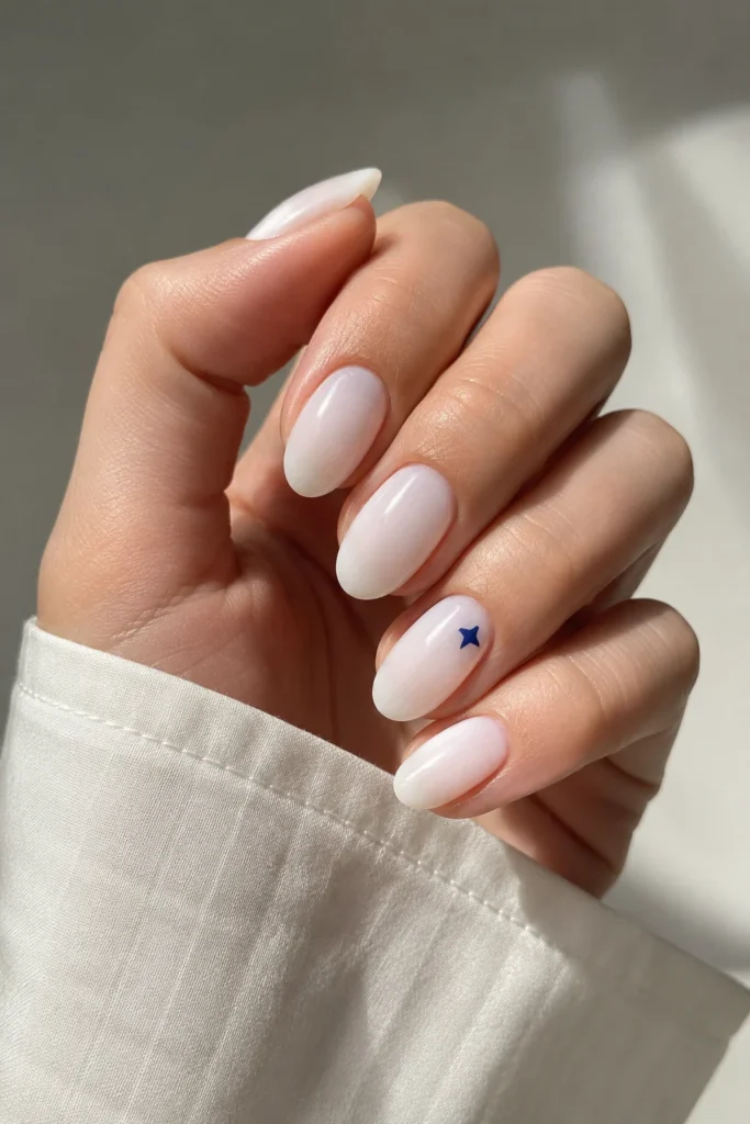 Glossy milky white nails with tiny blue star