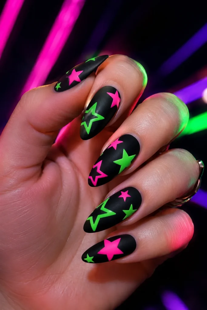 Neon pink and green stars on matte black nails