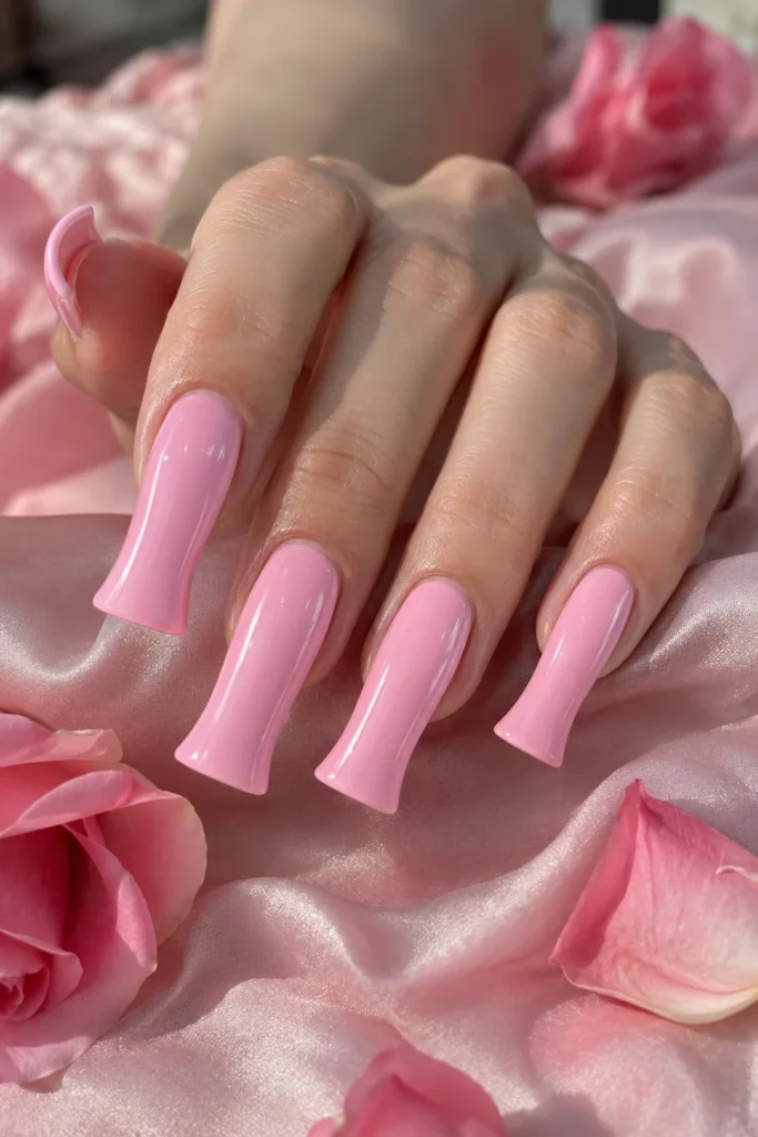 Glossy pink duck nails with a wide flared tip