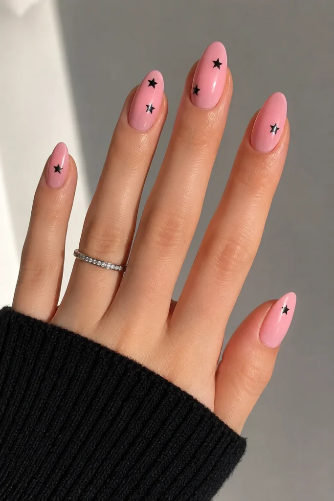 Pink nails with minimal black star accents