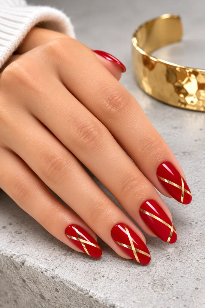 Red nails featuring modern gold geometric line art