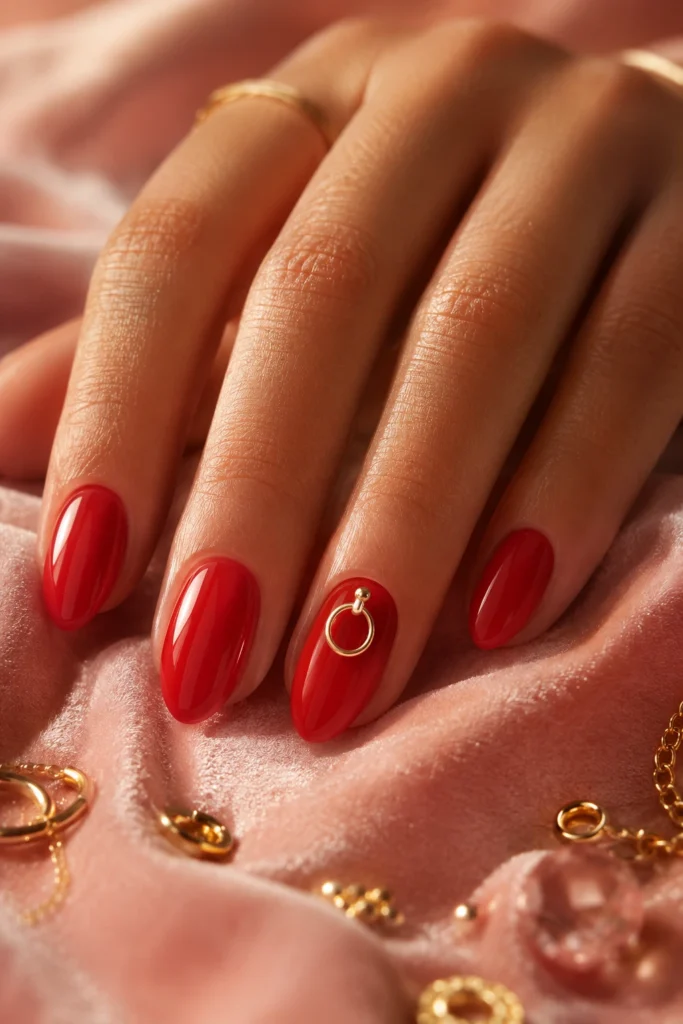 Red manicure with tiny gold hoop nail charm