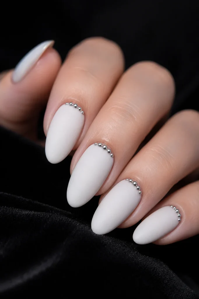 Matte white almond nails with silver bead details