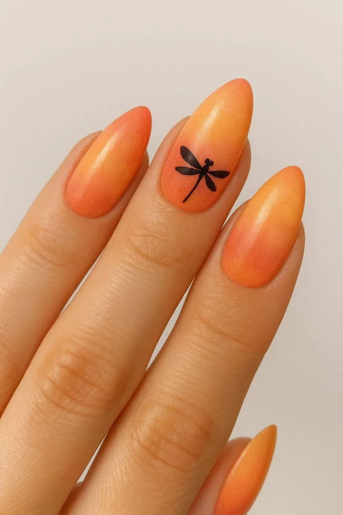 Peach and coral nails with dragonfly silhouette design