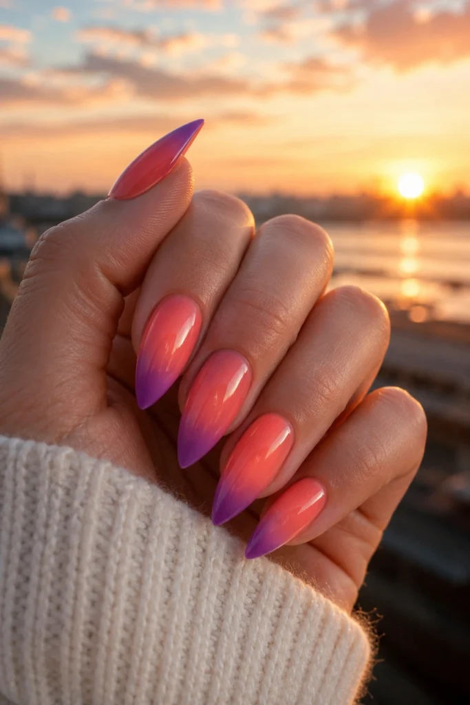 Pointy nails with orange, pink, and purple sunset ombre gradient