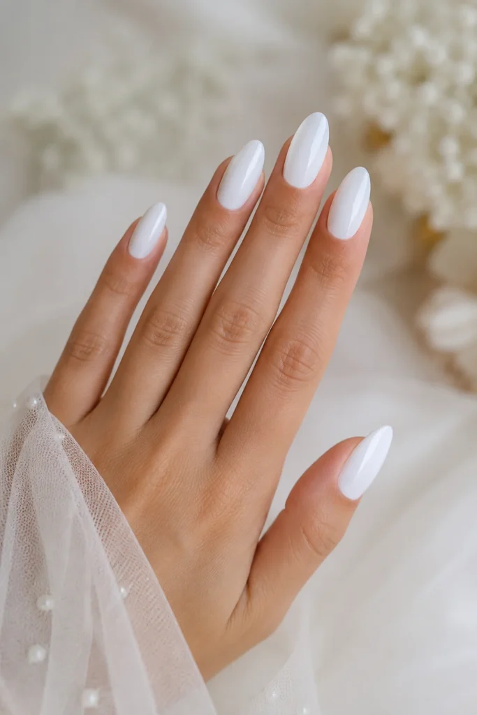 Glossy white almond shaped bridal nail manicure design