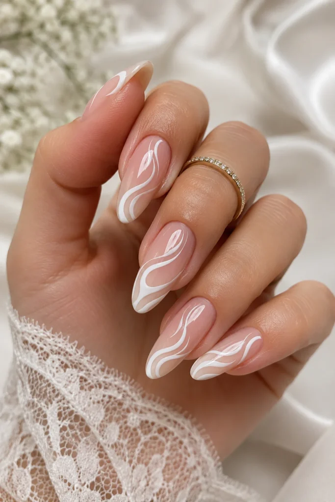 White swirl art on nude bridal nails