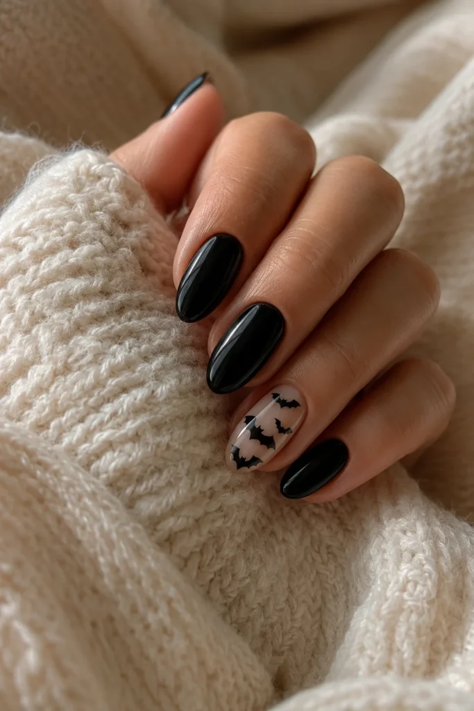 Black Halloween nails featuring tiny bat silhouette accent nail art