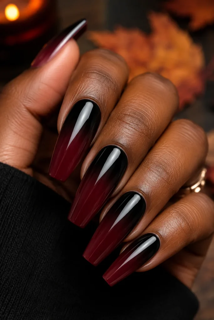 Long coffin nails with black-to-burgundy ombre gradient and glossy finish.