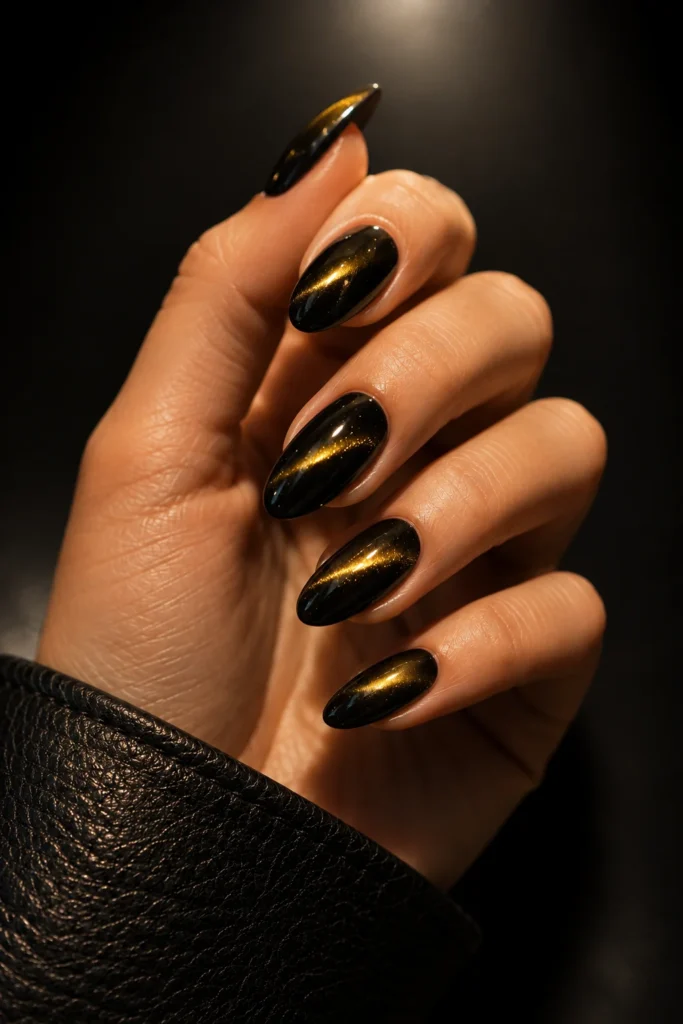 Black cat eye nails with glowing gold magnetic shine