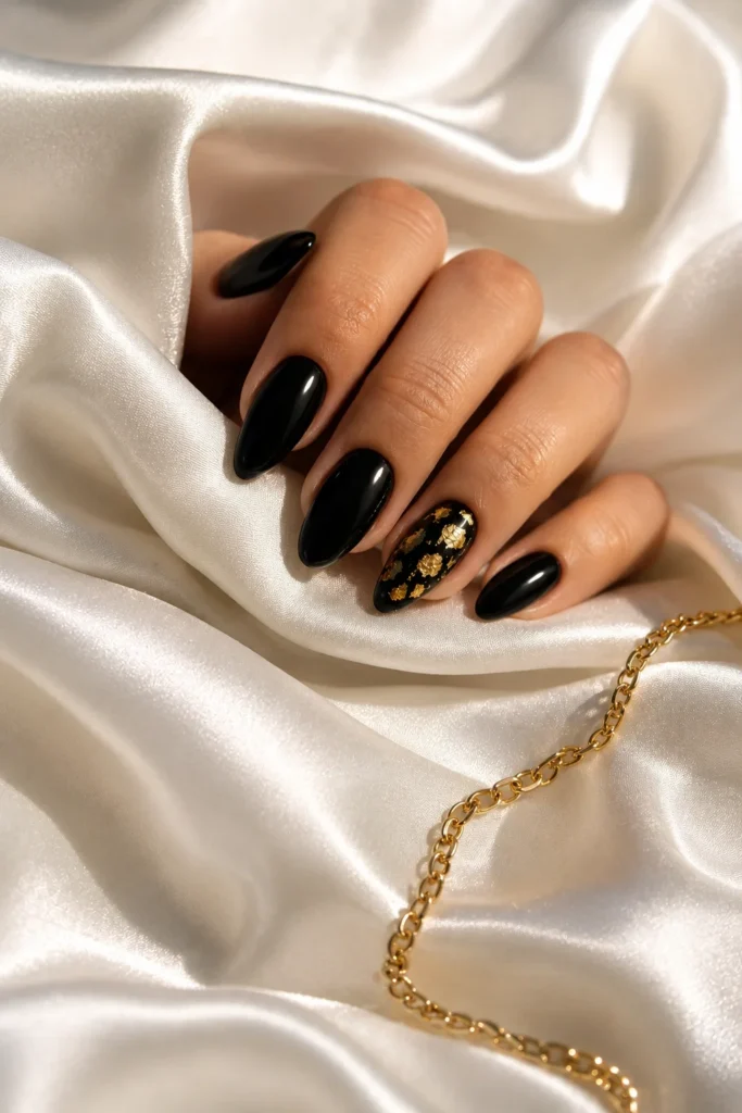 Black nails with gold foil accent nail design