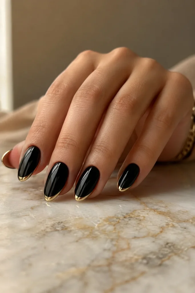 Black nails with elegant gold French tips