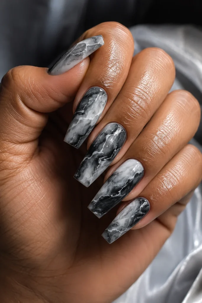 Long coffin nails with black and white marble stone pattern.