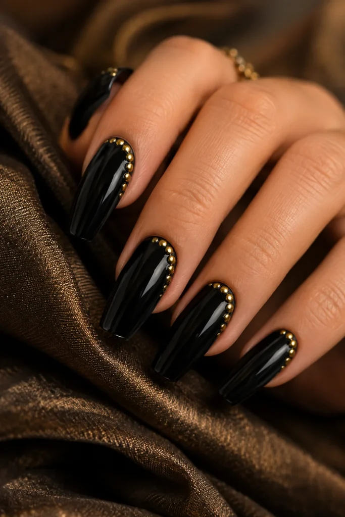 Short black nails decorated with delicate gold dots