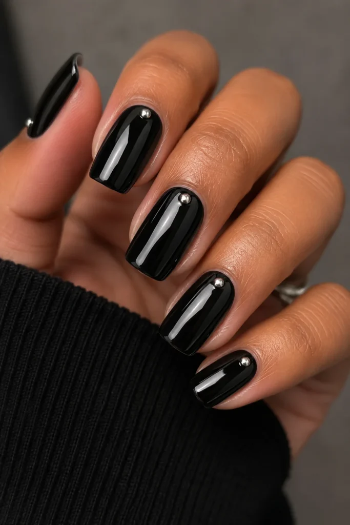 Glossy black square nails accented with tiny silver stud details.