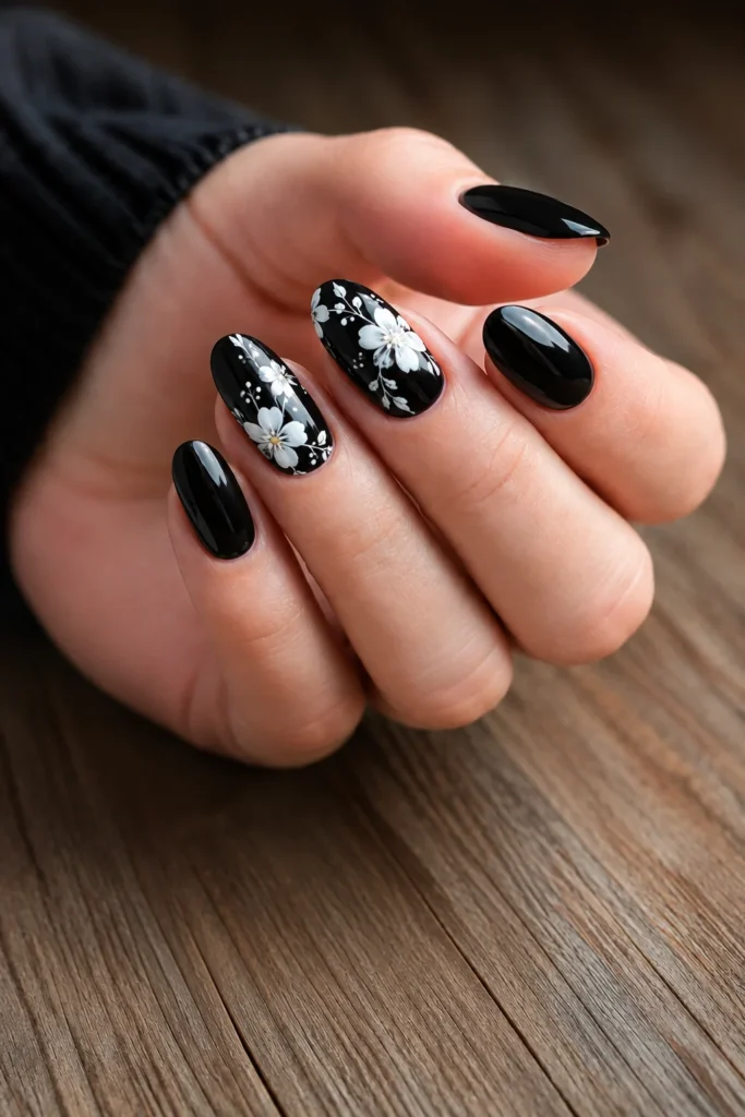 Black wedding nails featuring hand-painted white floral nail art