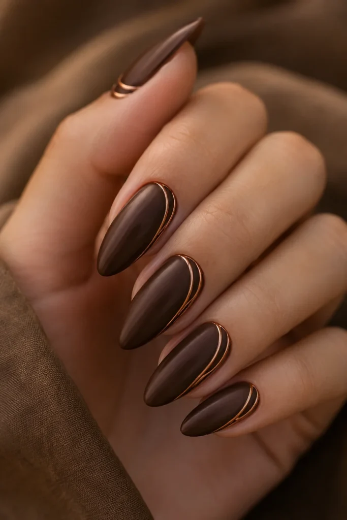 Chocolate brown almond nails lined with thin copper details