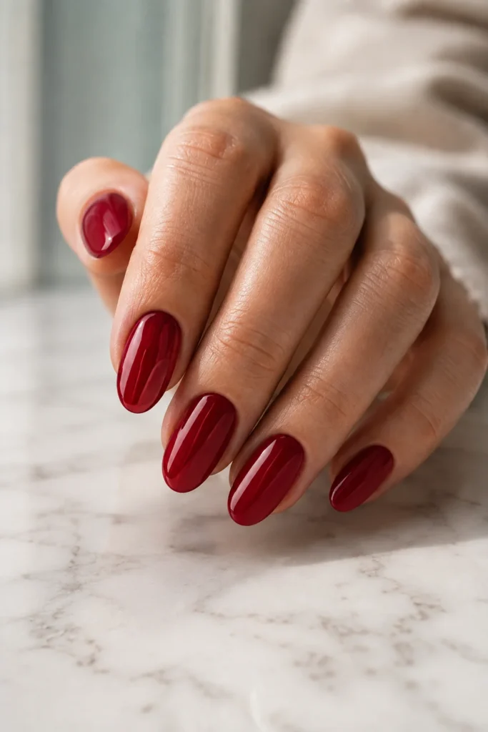 Classic glossy cherry red Valentine's Day nails on short almond nails