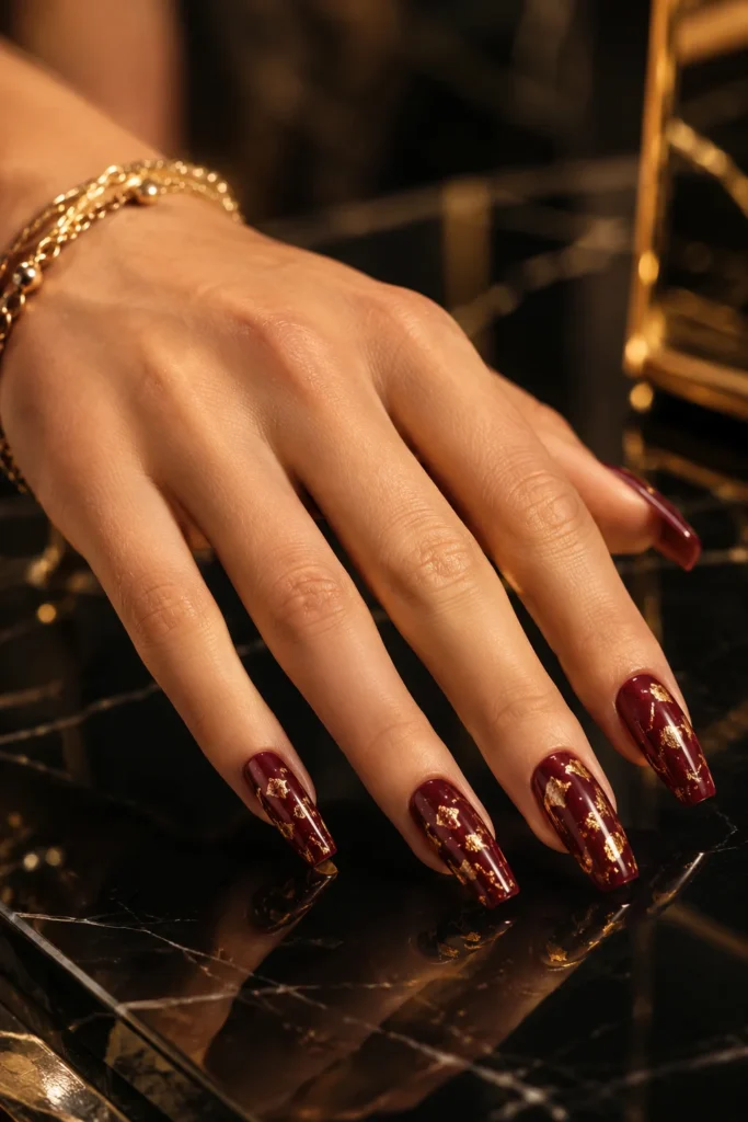 Dark red coffin nails decorated with gold foil accents