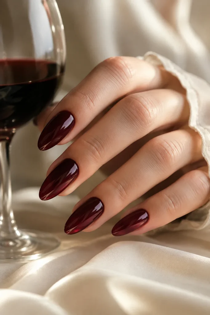 Deep plum jelly almond nails with a glassy finish