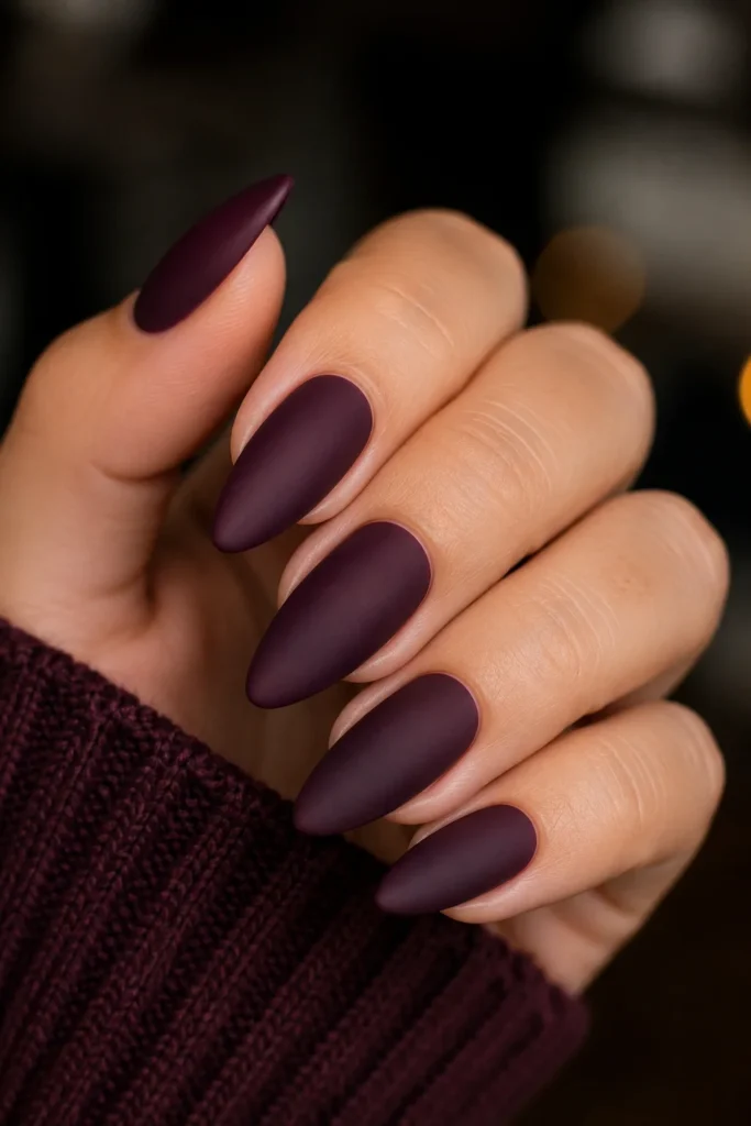 Almond-shaped nails in deep plum velvet matte polish finish